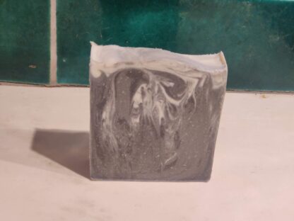 Photo of dramatic black soap with swirls of grey and white
